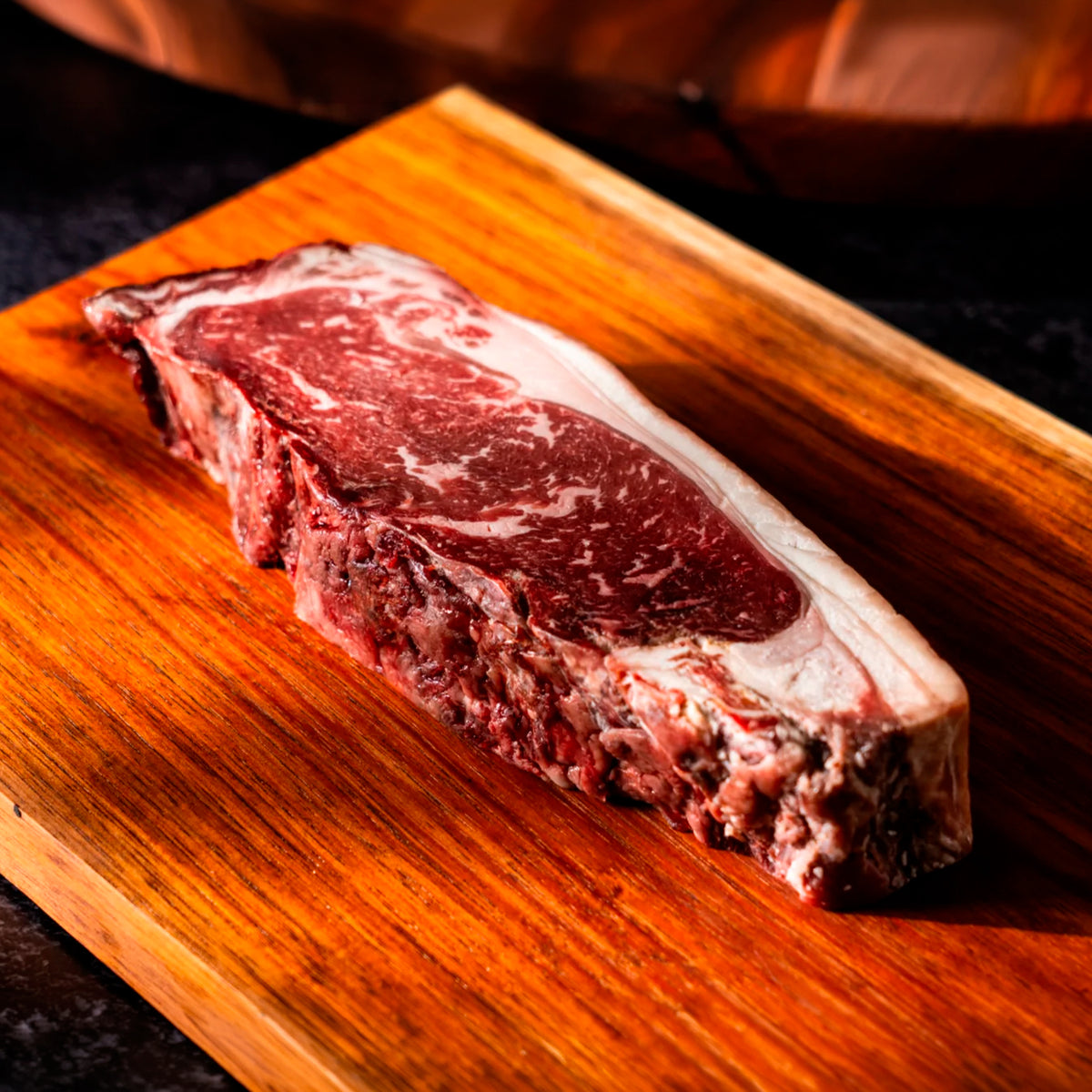 New York Dry Aged LHA — corte crudo en tabla de madera | MEAT MX